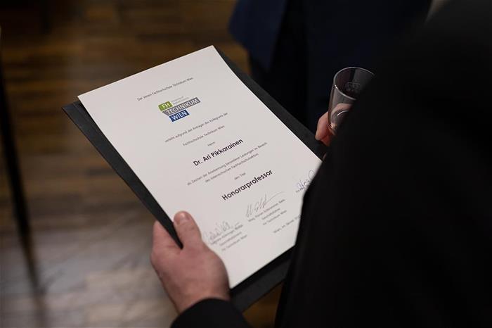 Todistus kunniaprofessuurista Arin kädessä.