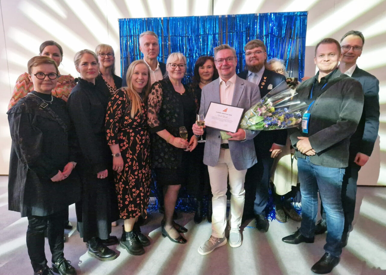 Joukko iloisia ihmisiä seisomassa.