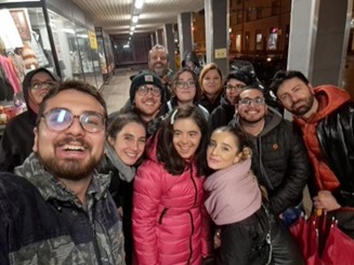 People are all wearing different colours. They are all smiling at the camera.