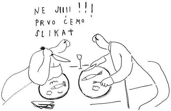 A black-and-white sketch shows two seated figures at a table, each with a plate containing a fish, using a knife and fork. Above the scene is handwritten text reading “NE J!!! PRVO ĆEMO SLIKAT,” and a small glass is placed between the two plates.