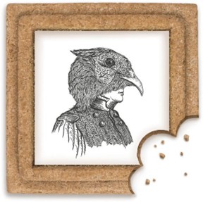 A  small black-and-white illustration shows a human profile combined with a bird’s head, featuring a long beak and detailed feather textures. The illustration is embedded into a traditional Croatian spicy pepper cookie, with a bite taken from one corner and crumbs visible beside it.