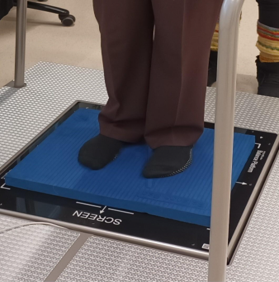 Testattava seisomassa IBalance tasapainon mittauslaitteen voimalevyllä.