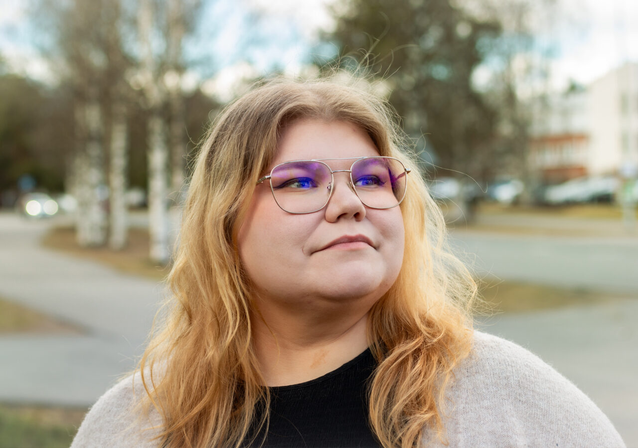 henkilö silmälasit päässä ulkona katsoo ylöspäin